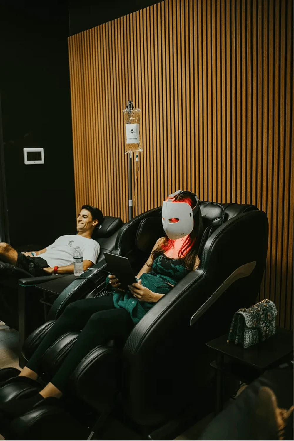 Patient wearing an LED red light mask in the recovery lounge at InnerWorks