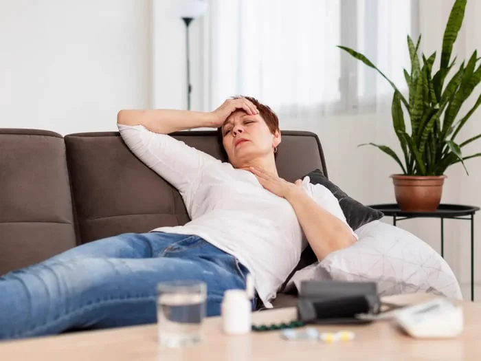 A red-haired woman on a sofa fights a hormone imbalance.
