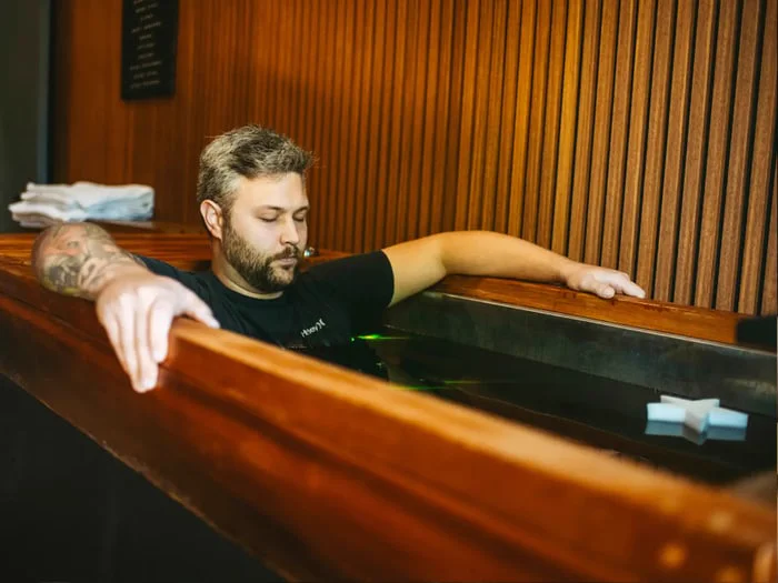 A bearded man uses an ice bath at a performance and wellness lab